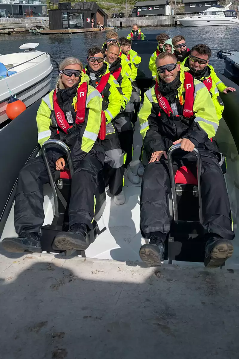 Smilende gruppe i RIB-båt klare for opplevelse på sjøen